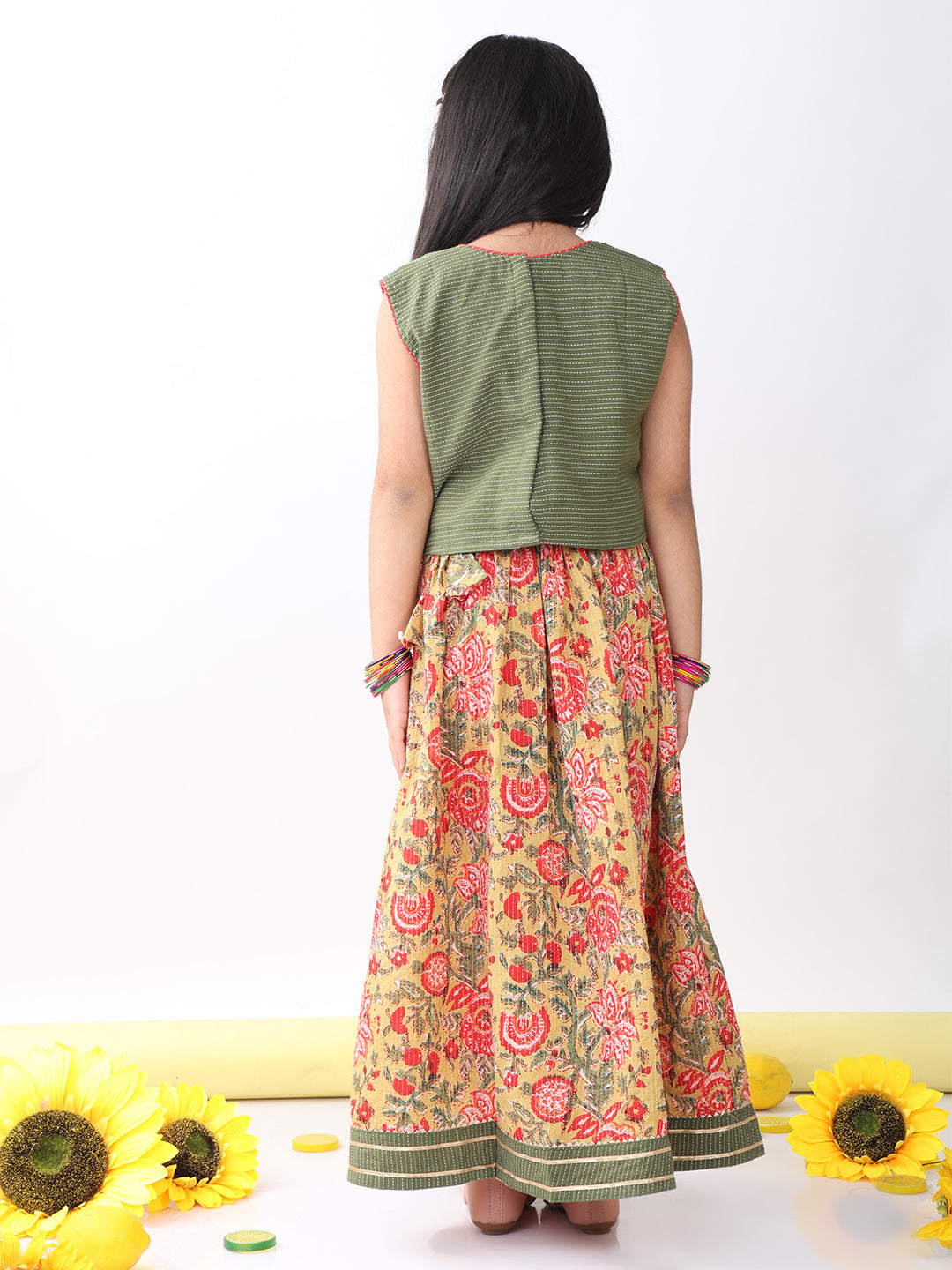 Green sleeveless embroidered blouse paired with printed lehenga