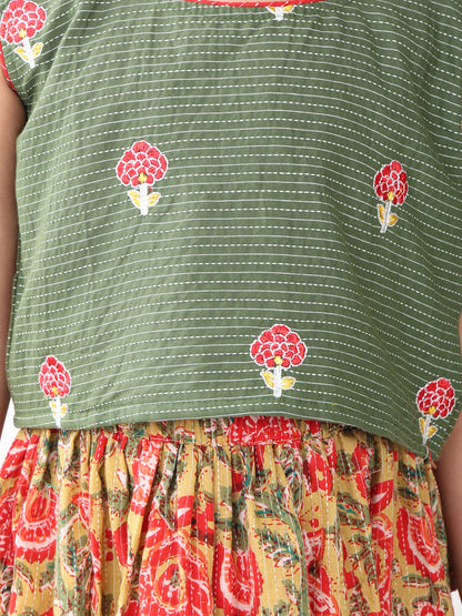 Green sleeveless embroidered blouse paired with printed lehenga